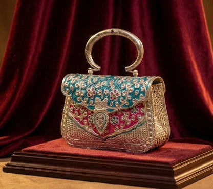 Antique oxidised brass clutch bag with blue and pink Meenakari and red-stone Parchi Kundan work