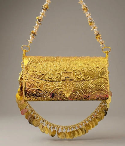 Full golden metal clutch bag with engraved floral patterns, hanging gold coin fringe, and pearl-beaded handle