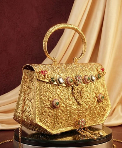 Luxury gold-look bridal clutch with ornate top handle, long chain sling, detailed heritage motifs and colourful embellishments for weddings and festive occasions.