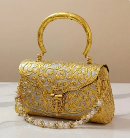 Ornate Meenakari brass bag with golden floral pattern and pearl detailing