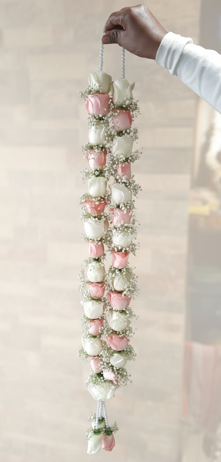 Pink and ivory rose buds with white baby’s breath on a traditional Indian wedding flower garland
