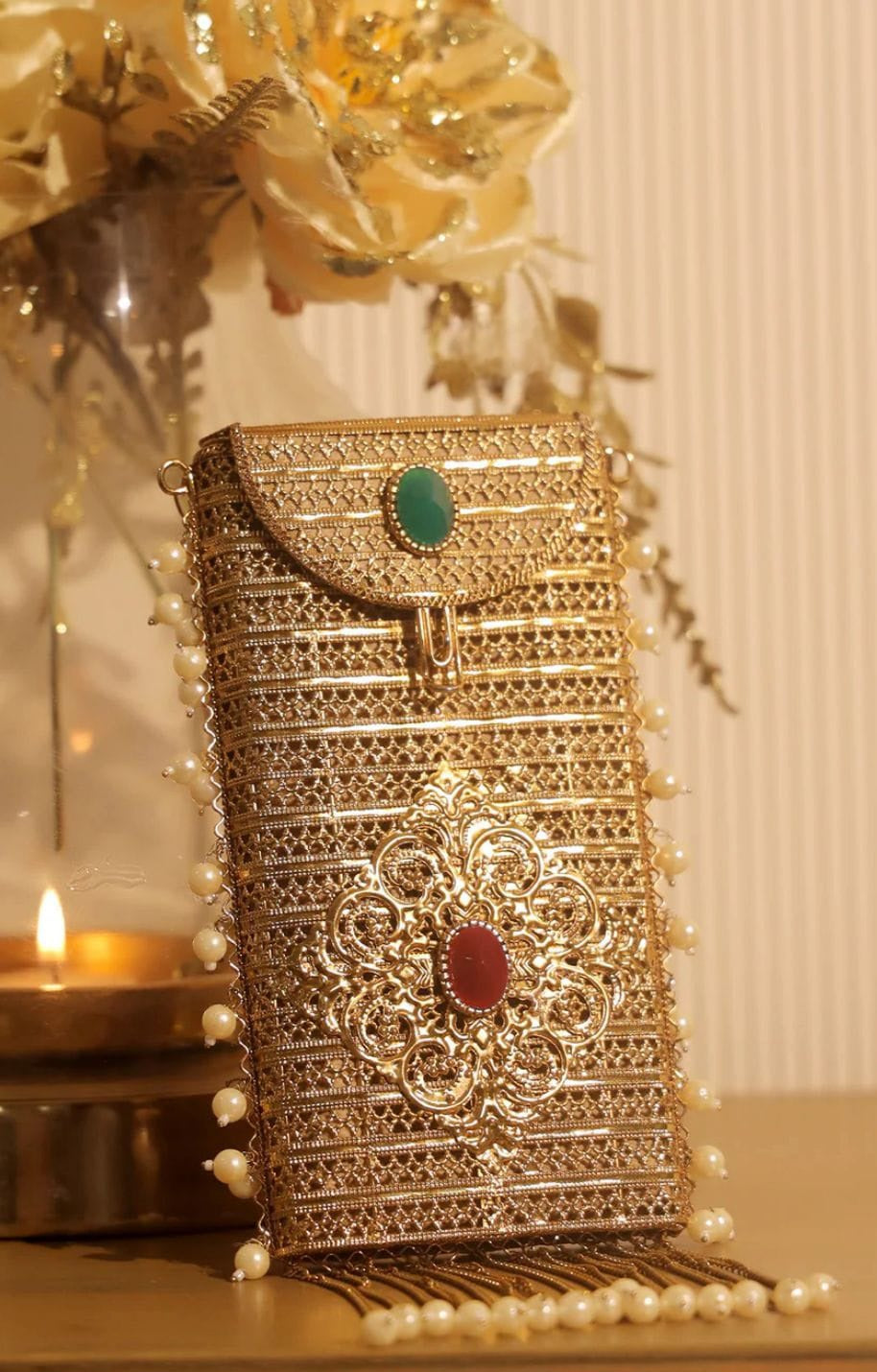 Royal emerald brass clutch bag with pearl tassels and ethnic detailing