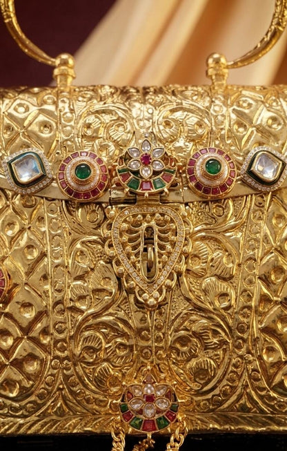 Traditional Indian wedding handbag in a rich gold finish with heritage floral embossing, decorative stone embellishments and a structured 8 x 7 inch design.