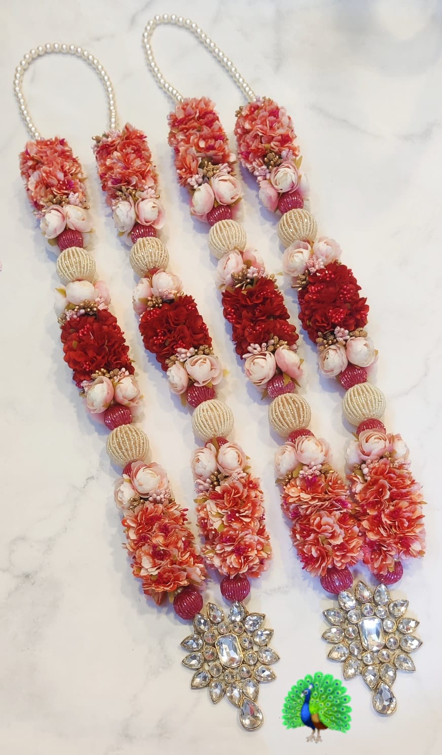 Pearl and kundan-style embellishments on a bride and groom wedding garland